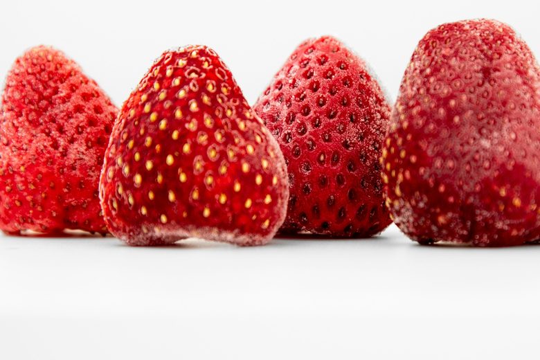 A row of frozen strawberries dusted with frost